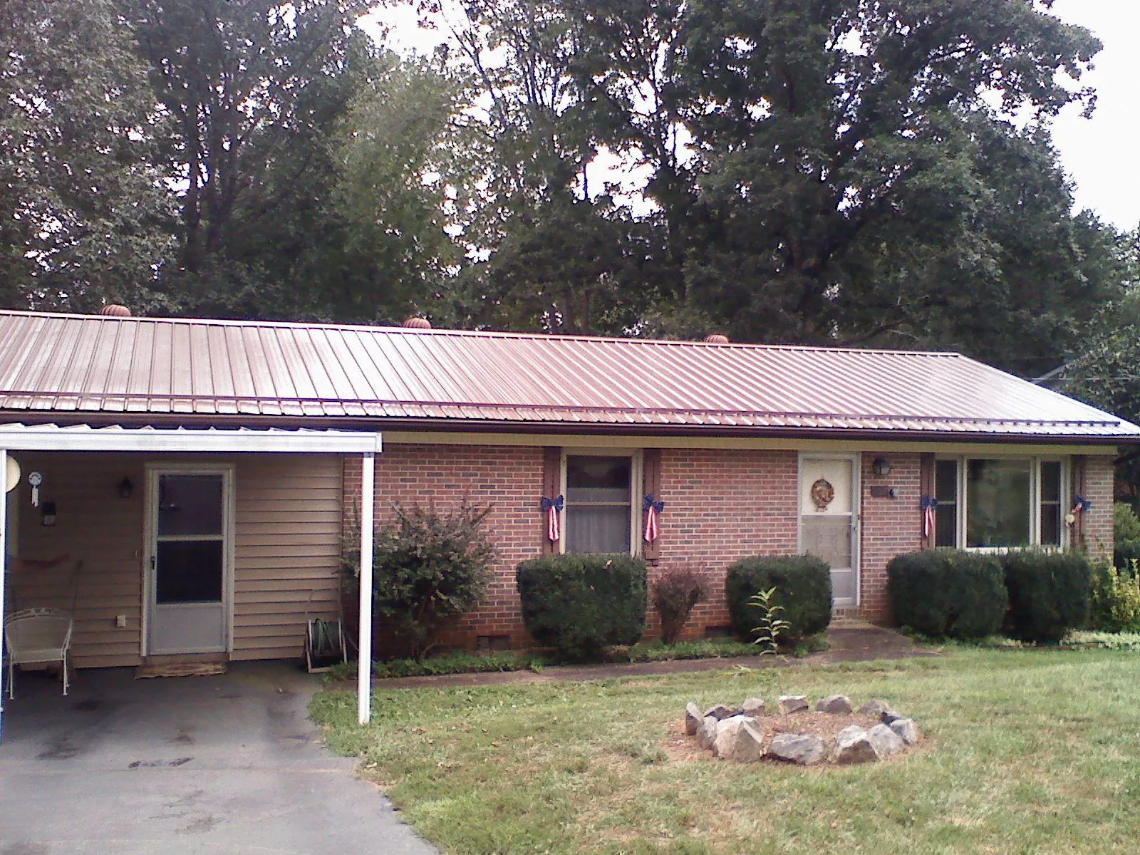 Bronze metal roof and carport on a brick ranch home — Roof Repair work by our crew in Little River